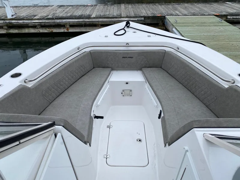 Slide: The Image of 2023 Sea Pro 240 DC boat with spacious bow seating at the dock. - 2