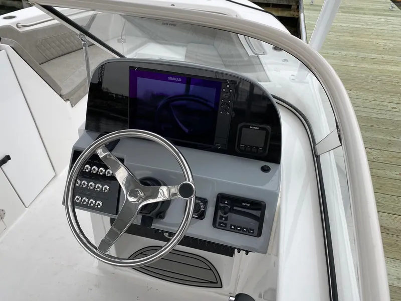 Slide: The Image of 2023 Sea Pro 240 DC boat dashboard with steering wheel and navigation system. - 5