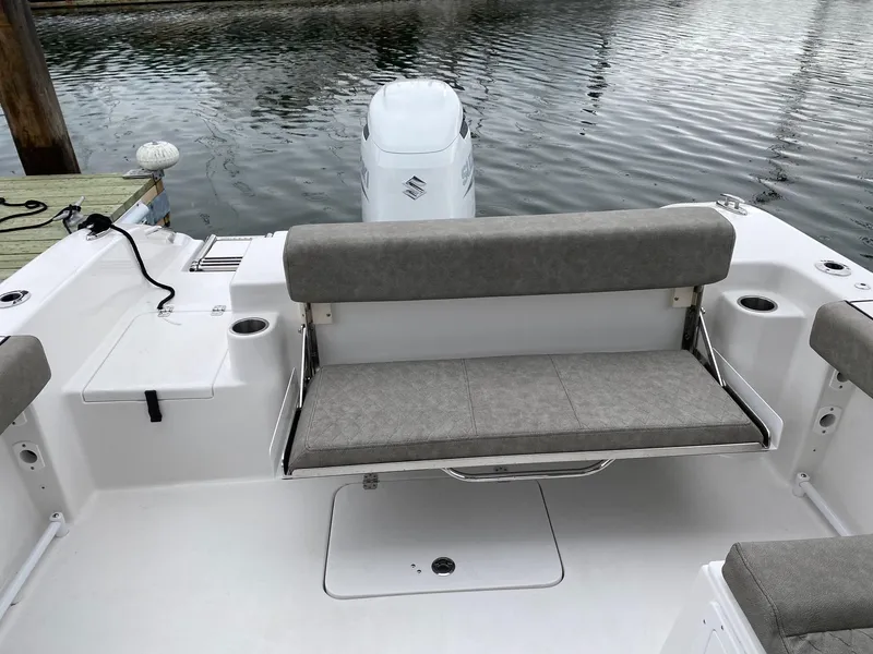 Slide: The Image of 2023 Sea Pro 240 DC boat with cushioned seating and outboard motor at dock. - 6