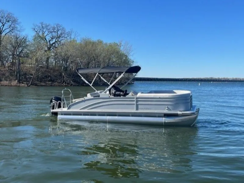 Slide: The Image of 2023 Harris CRUISER 230 SLDH pontoon boat on a calm lake. - 11
