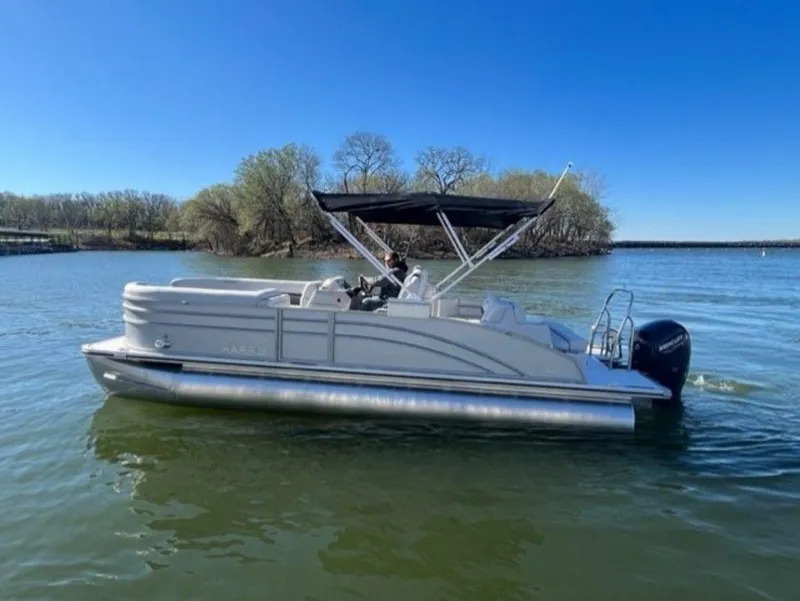 Slide: The Image of 2023 Harris CRUISER 230 SLDH pontoon boat on a calm lake. - 13