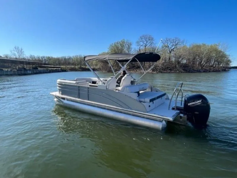 Slide: The Image of 2023 Harris CRUISER 230 SLDH pontoon boat on a calm lake. - 14