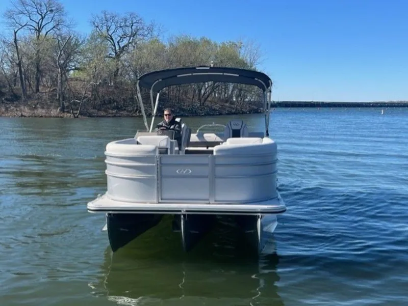 Slide: The Image of 2023 Harris CRUISER 230 SLDH pontoon boat on a lake with a person at the helm. - 9