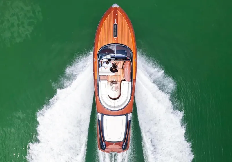 Slide: The Image of Top view of 2020 Riva Aquariva Super luxury yacht cruising on green water. - 2
