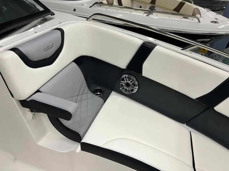 Slide: The Image of 2023 Chaparral 270 OSX boat interior with white and black seating, speaker, and cup holder. - 12