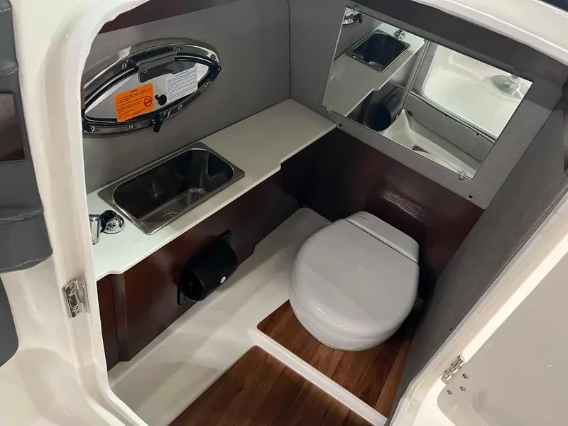 Slide: The Image of 2023 Chaparral 270 OSX boat interior bathroom with sink, toilet, and mirror. - 14