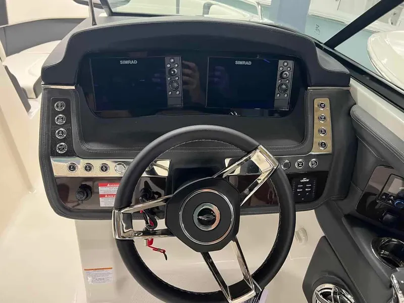 Slide: The Image of 2023 Chaparral 270 OSX boat dashboard with dual Simrad displays and modern steering wheel. - 18