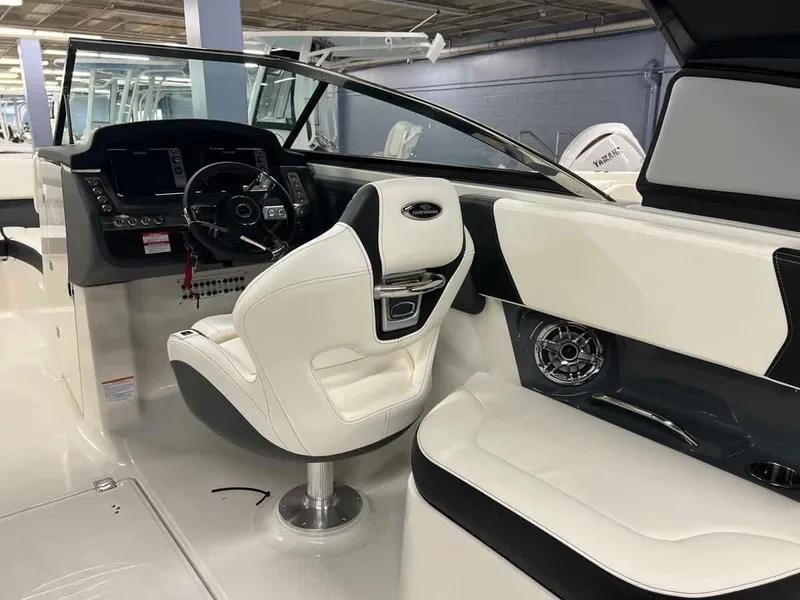 Slide: The Image of 2023 Chaparral 270 OSX boat interior with helm, steering wheel, and white seating. - 19