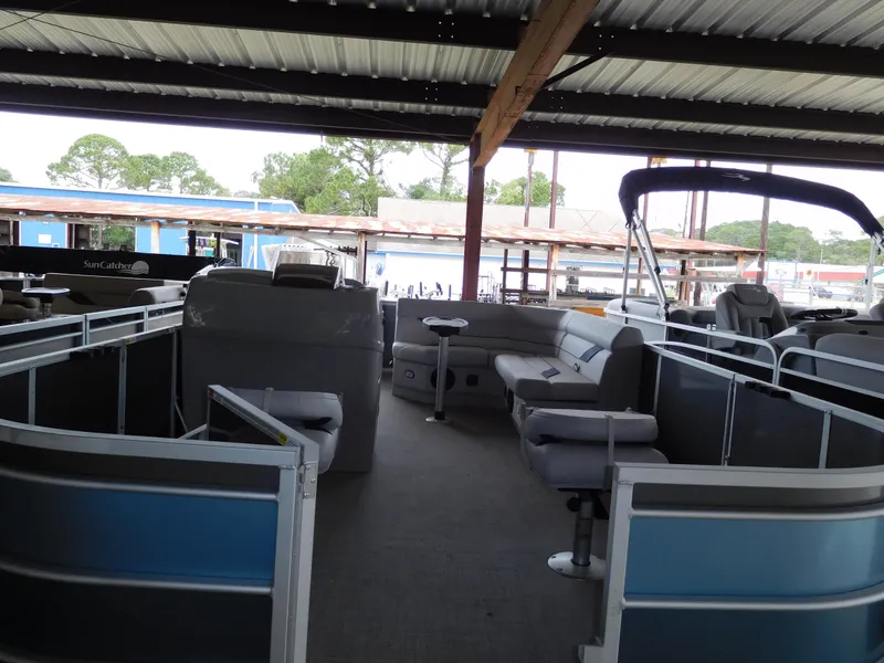 Slide: The Image of 2023 SunCatcher 20 Fish pontoon boat interior under a covered dock. - 2