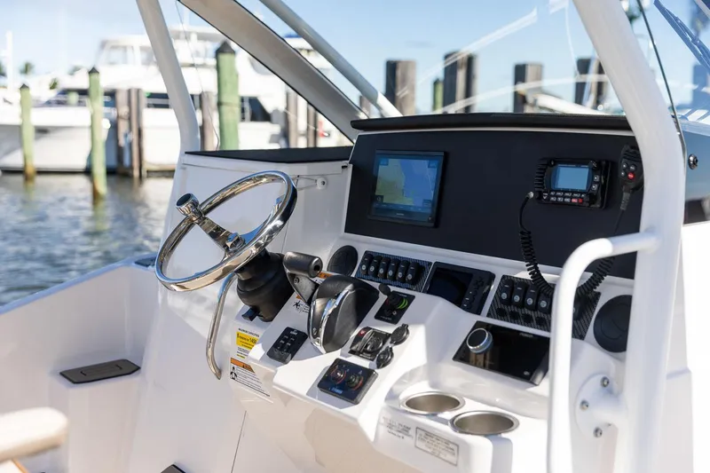 Slide: The Image of Control panel of 2023 Solara S-250 CW boat with steering wheel and navigation system. - 16