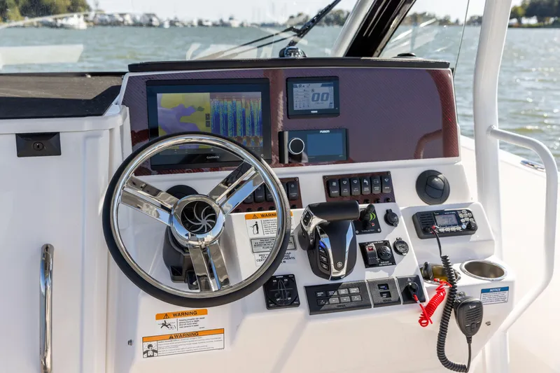 Slide: The Image of 2023 Solara S-250 CW boat dashboard with steering wheel, navigation screens, and control panel. - 17