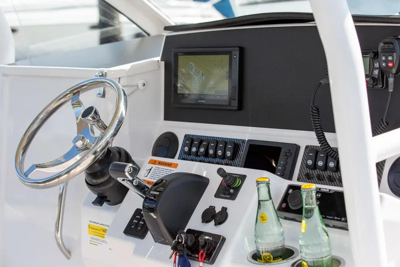 Slide: The Image of Control panel of 2023 Solara S-250 CW boat with steering wheel and navigation screen. - 19