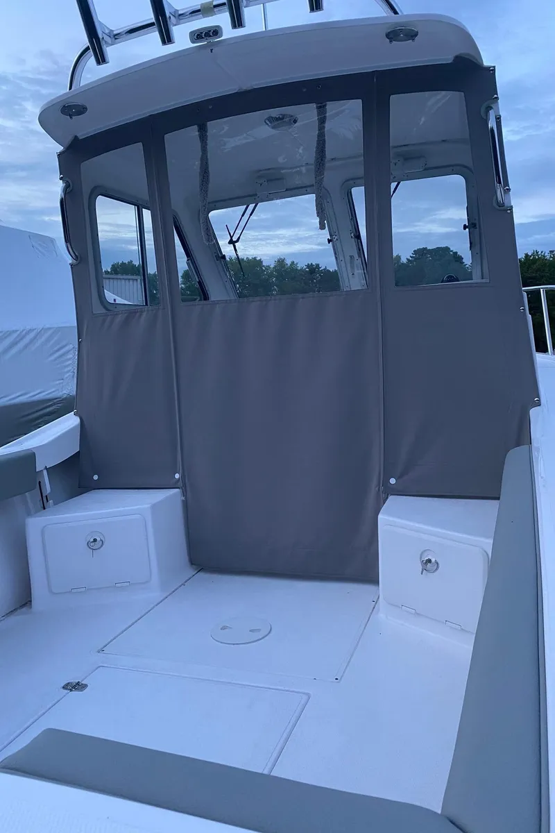 The Image of 2019 NorthCoast 215 HT boat with enclosed cabin, gray cover, and white deck. - 1