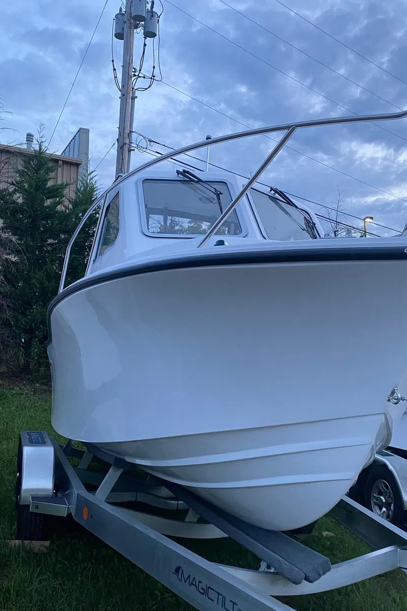Slide: The Image of 2019 NorthCoast 215 HT boat on trailer, parked outdoors under cloudy sky. - 3