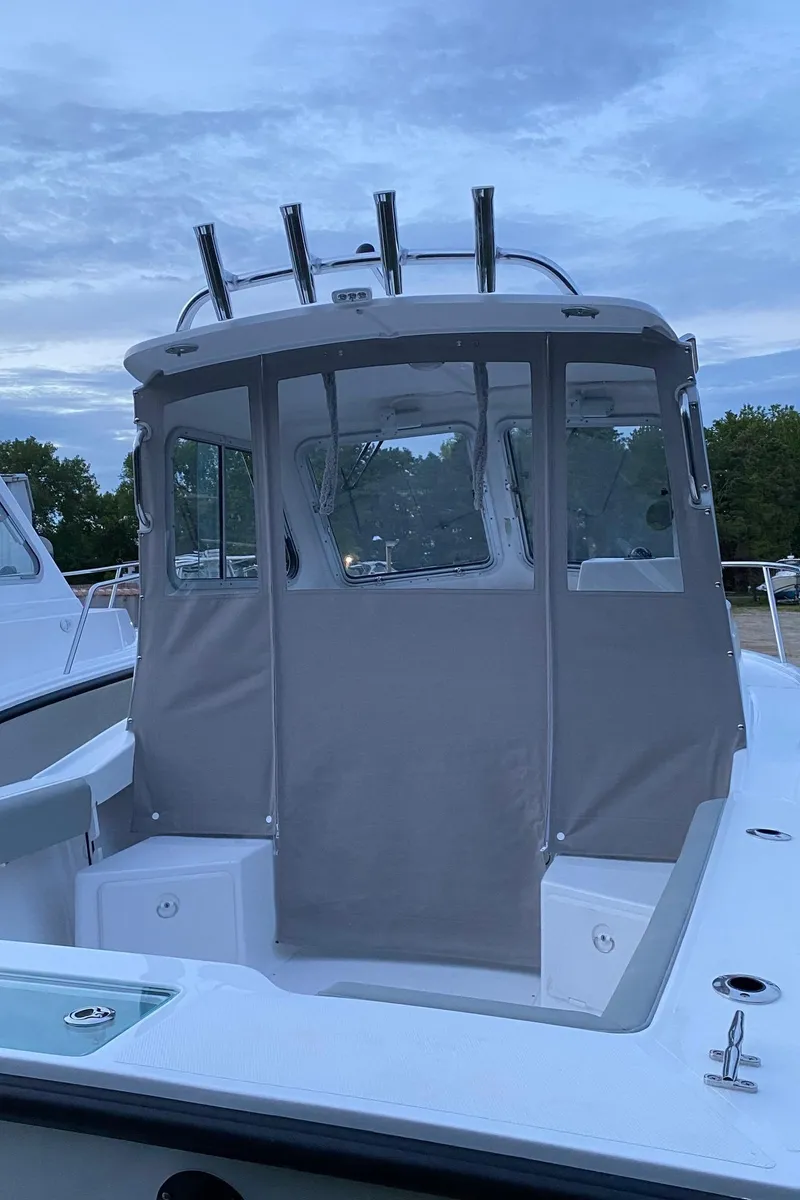 Slide: The Image of 2019 NorthCoast 215 HT boat with enclosed cabin, docked under a cloudy sky. - 5