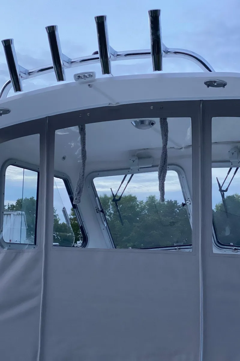 Slide: The Image of 2019 NorthCoast 215 HT boat with enclosed cabin and rod holders, set against a cloudy sky. - 9