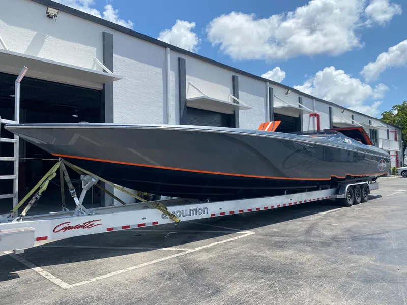 Slide: The Image of 2023 Cigarette 515 powerboat on a trailer outside a warehouse under a blue sky. - 1