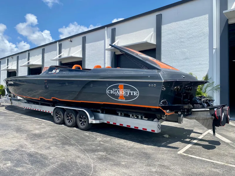 Slide: The Image of 2023 Cigarette 515 powerboat on a trailer outside a warehouse. - 2