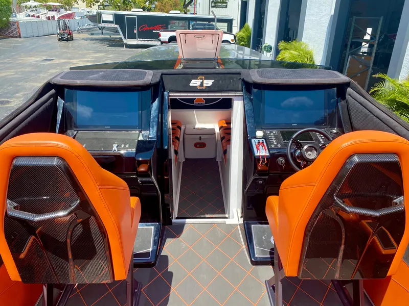 Slide: The Image of Interior of a 2023 Cigarette 515 boat with orange seats and dual control panels. - 6