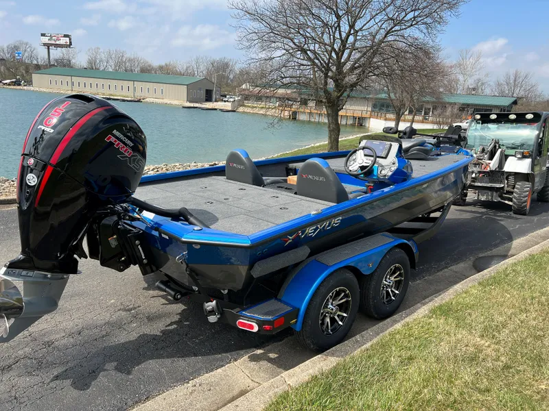 Slide: The Image of 2023 Vexus AVX1980 boat on trailer by a lake, featuring a powerful outboard motor. - 3