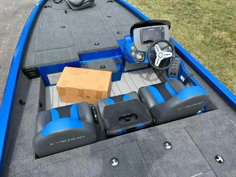 Slide: The Image of 2023 Vexus AVX1980 boat interior with blue and gray seats and a cardboard box. - 8