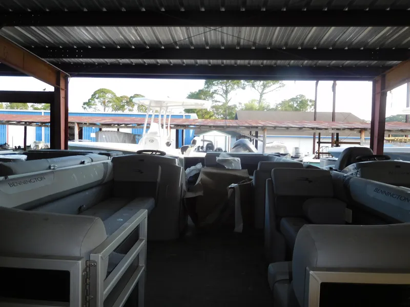 Slide: The Image of 2023 Bennington 22 SLX pontoon boat interior under a covered dock. - 3
