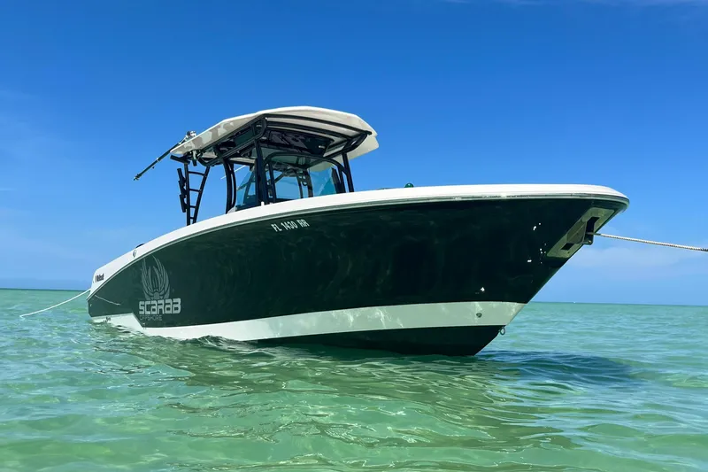 Slide: The Image of 2018 Wellcraft 302 Fisherman boat anchored in clear blue water. - 2