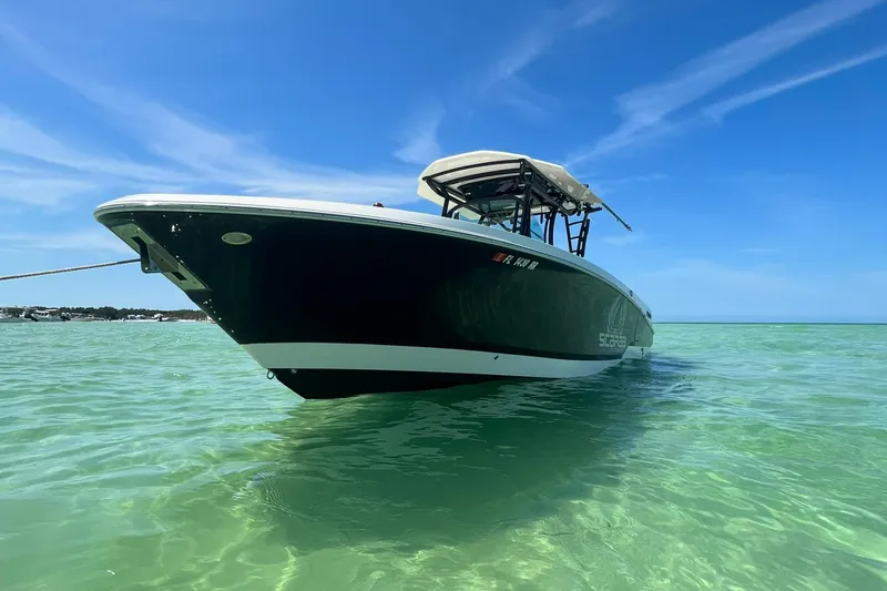 Slide: The Image of 2018 Wellcraft 302 Fisherman boat anchored in clear turquoise water. - 3