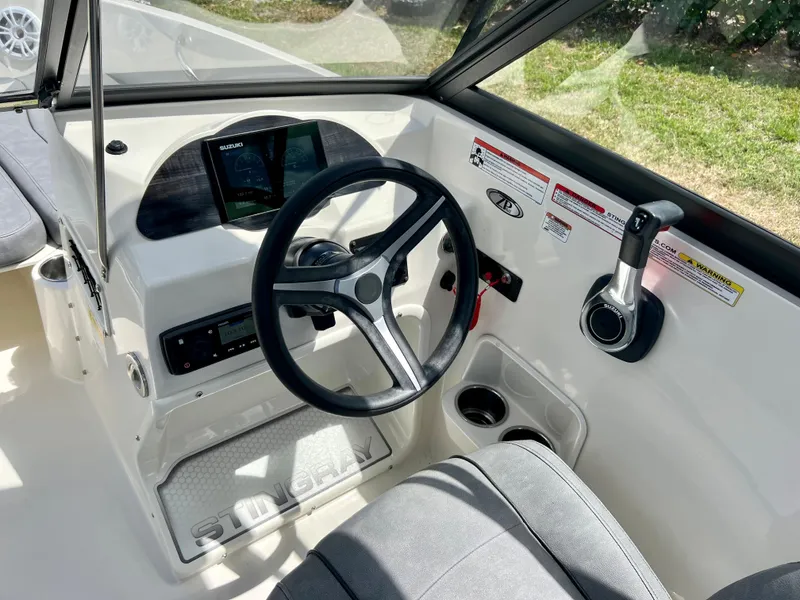 Slide: The Image of 2021 Stingray 191 DC boat cockpit with steering wheel and control panel. - 17