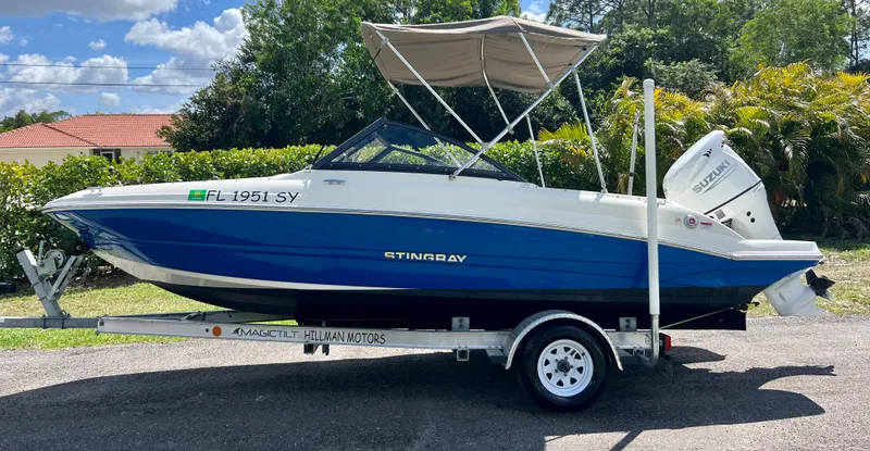 Slide: The Image of 2021 Stingray 191 DC boat on trailer with canopy. - 2