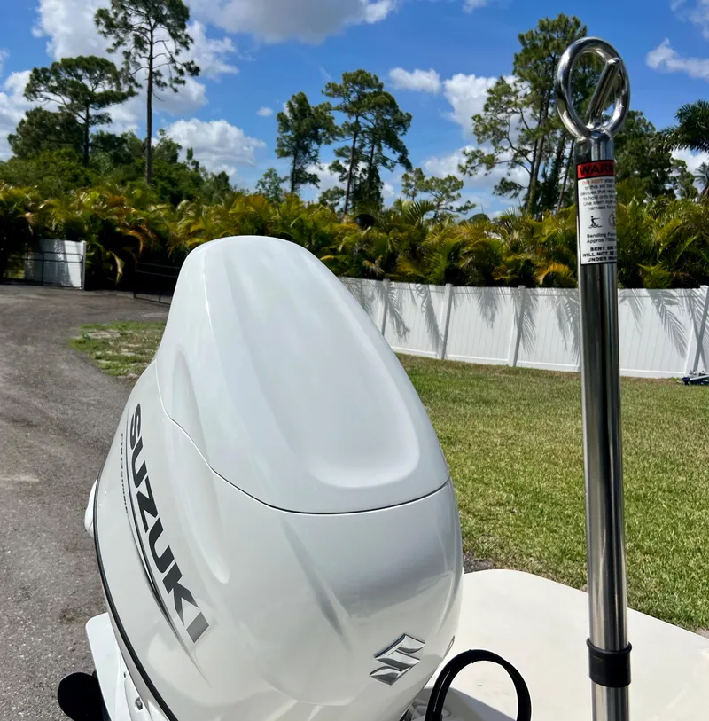 Slide: The Image of 2021 Stingray 191 DC with Suzuki outboard motor in a sunny outdoor setting. - 22