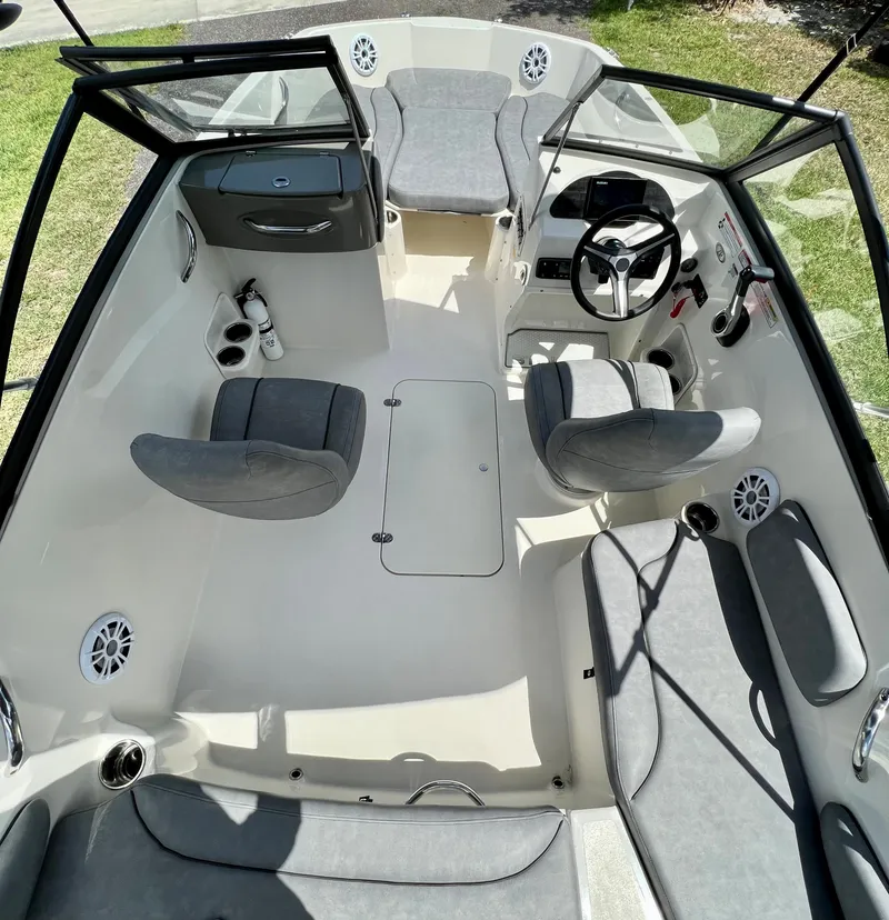 Slide: The Image of 2021 Stingray 191 DC boat interior with gray seating and steering console. - 25