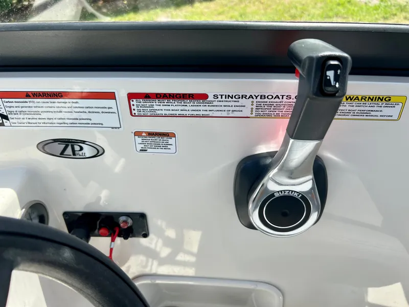 Slide: The Image of 2021 Stingray 191 DC boat control panel with Suzuki throttle and warning labels. - 26