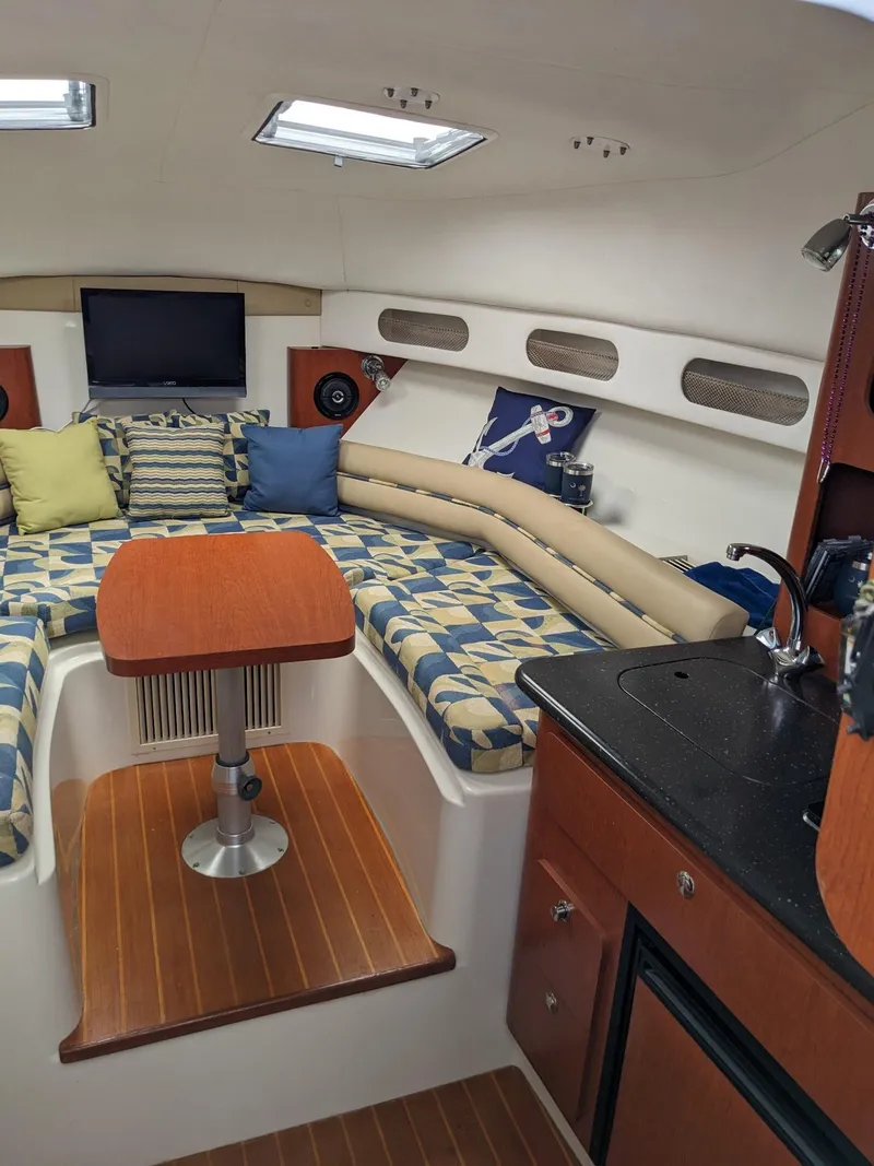 Slide: The Image of 2008 Pro-Line 32 Express cabin with seating, table, and kitchenette. - 10