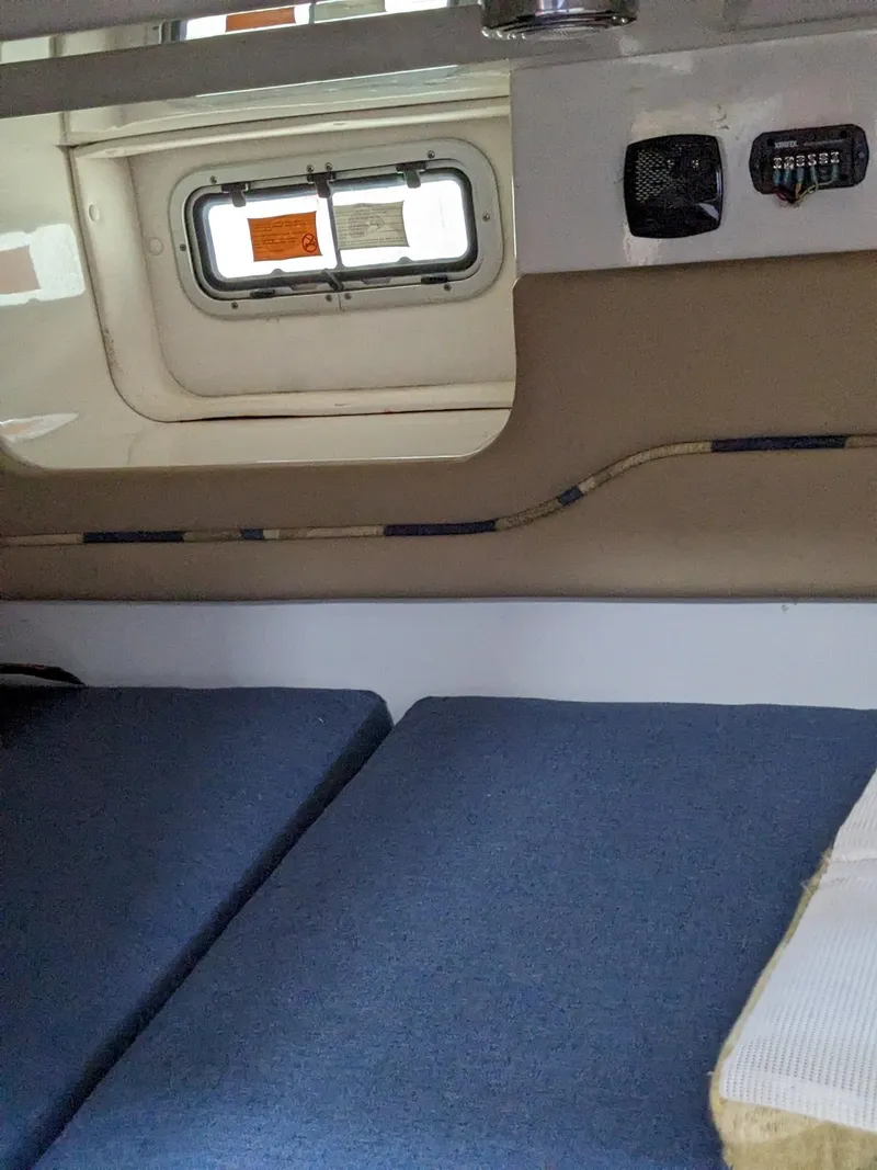 Slide: The Image of Interior cabin of 2008 Pro-Line 32 Express boat with blue cushions and a small window. - 13