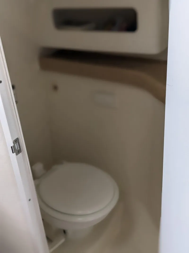 Slide: The Image of 2008 Pro-Line 32 Express boat bathroom with compact toilet and storage shelf. - 14