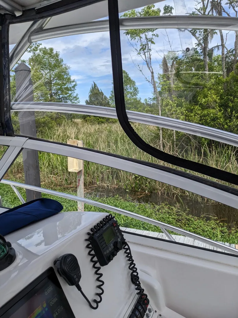 Slide: The Image of 2008 Pro-Line 32 Express boat interior with navigation equipment, overlooking lush greenery. - 17