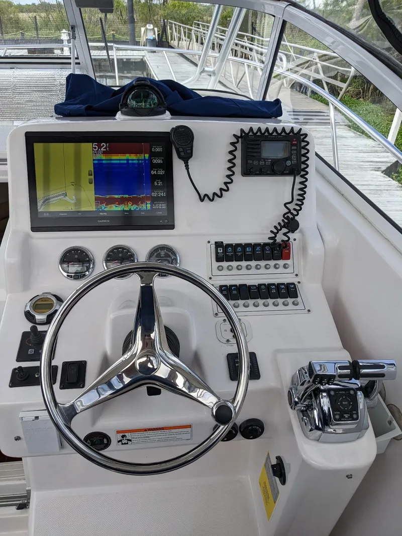 Slide: The Image of 2008 Pro-Line 32 Express boat helm with steering wheel, navigation screens, and controls. - 19