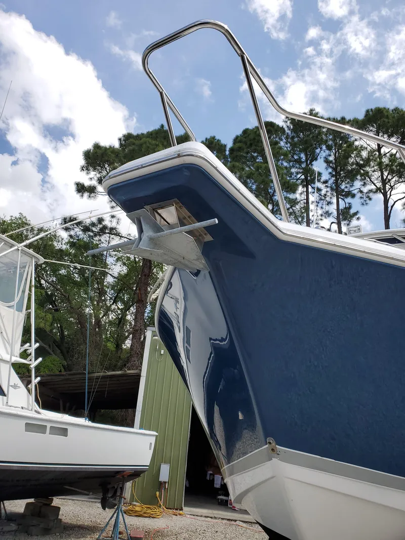 Slide: The Image of 2008 Pro-Line 32 Express boat with blue hull, docked outdoors under a cloudy sky. - 4