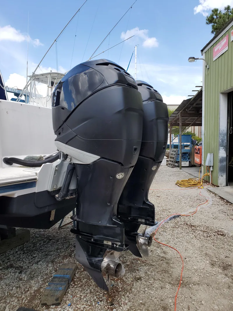 Slide: The Image of 2008 Pro-Line 32 Express boat with dual outboard motors, docked near a green building. - 5