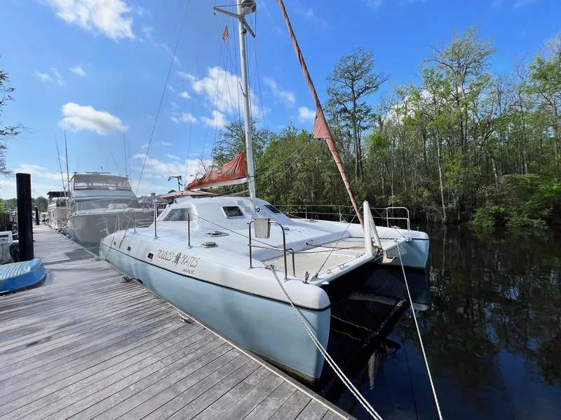 Slide: The Image of 1999 Wildcat 35 Catamaran docked at a marina on a sunny day. - 1