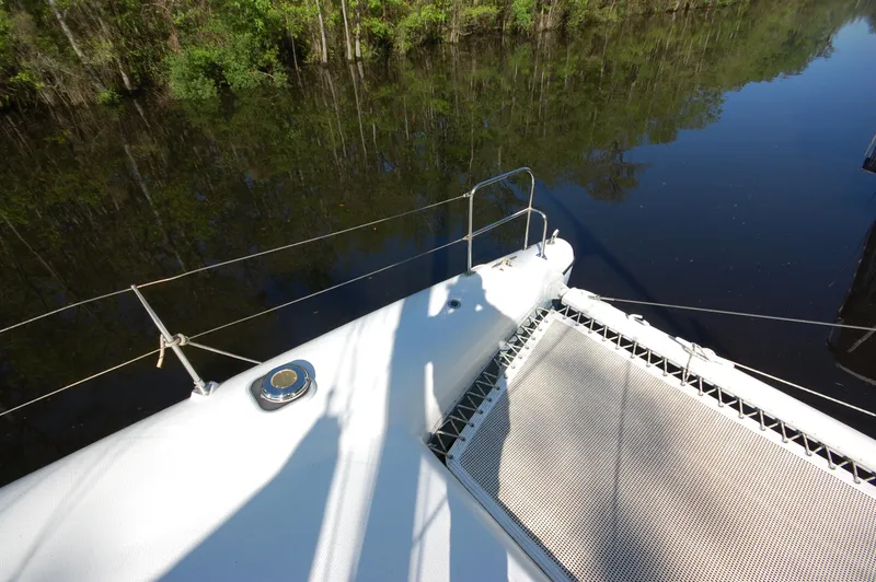 Slide: The Image of 1999 Wildcat 35 Catamaran deck view with netting and water reflection. - 16