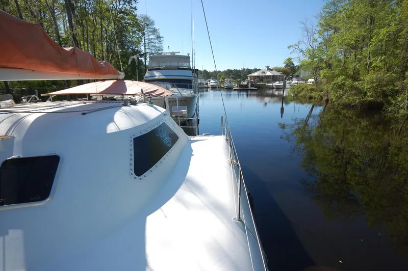 Slide: The Image of 1999 Wildcat 35 Catamaran docked in a serene, tree-lined marina. - 21