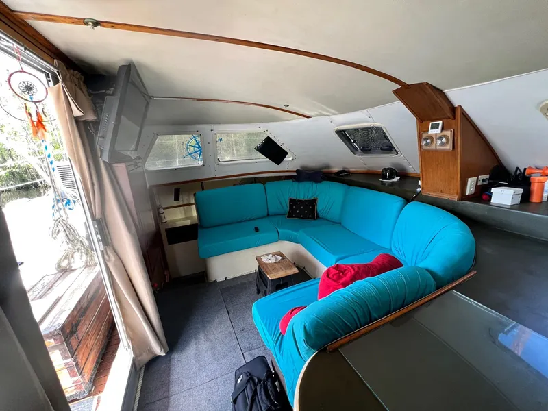 Slide: The Image of Interior of 1999 Wildcat 35 Catamaran with blue seating and wooden accents. - 28