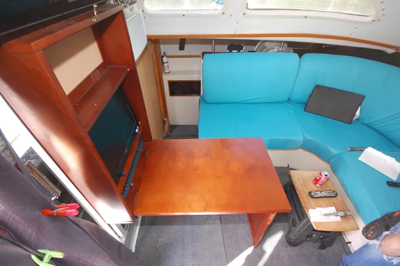 Slide: The Image of Interior of 1999 Wildcat 35 Catamaran with blue seating and wooden table. - 29