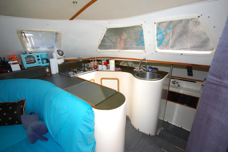 Slide: The Image of Interior of 1999 Wildcat 35 Catamaran with kitchen and seating area. - 31