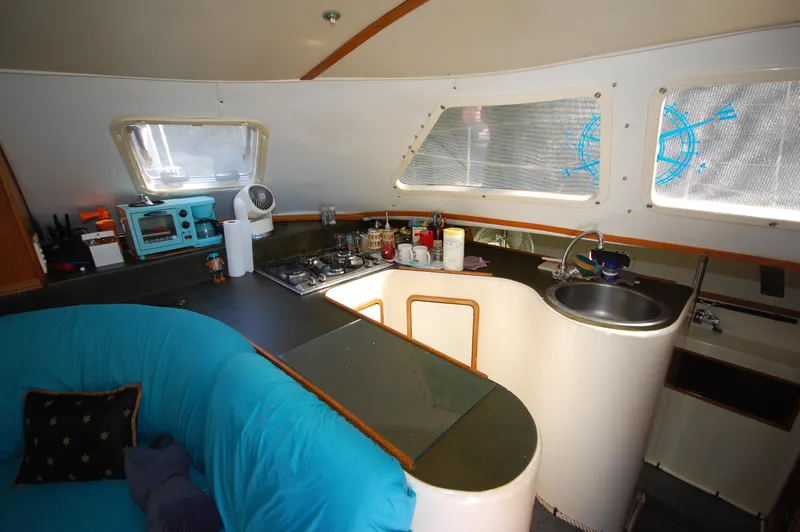 Slide: The Image of Interior of 1999 Wildcat 35 Catamaran kitchen and seating area. - 32