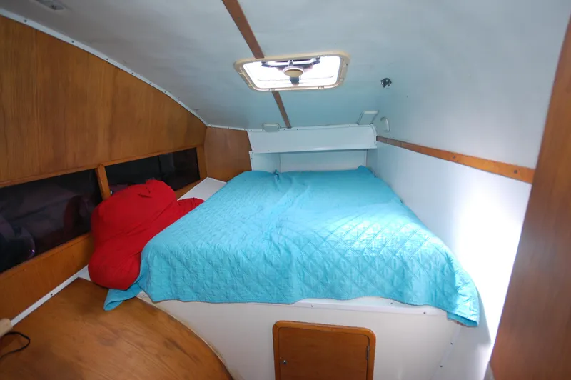 Slide: The Image of Cozy cabin interior of a 1999 Wildcat 35 Catamaran with a blue bedspread. - 34