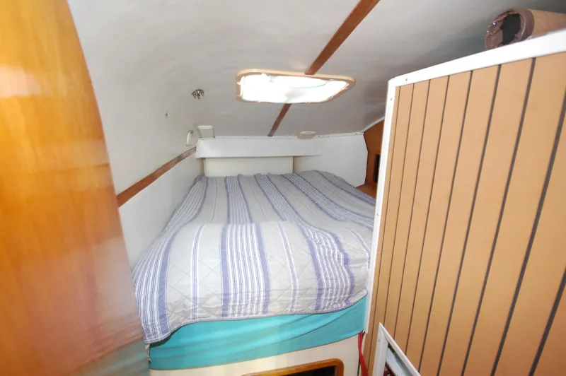 Slide: The Image of Cozy cabin interior of 1999 Wildcat 35 Catamaran with striped bedding. - 36