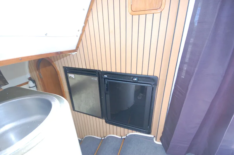 Slide: The Image of 1999 Wildcat 35 Catamaran interior with mini fridge and storage. - 39